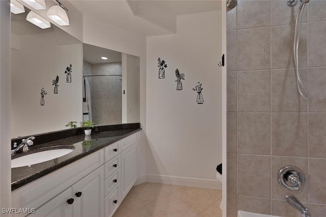 bathroom featuring shower / bath combination, a sink, baseboards, tile patterned floors, and double vanity