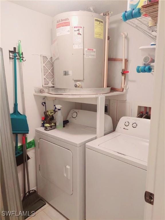 laundry area featuring laundry area, tile patterned flooring, water heater, and washing machine and clothes dryer