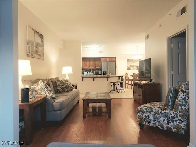 living room featuring dark wood-style floors, visible vents, and a toaster