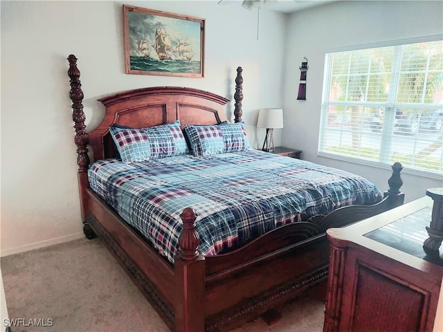 bedroom featuring light carpet and baseboards