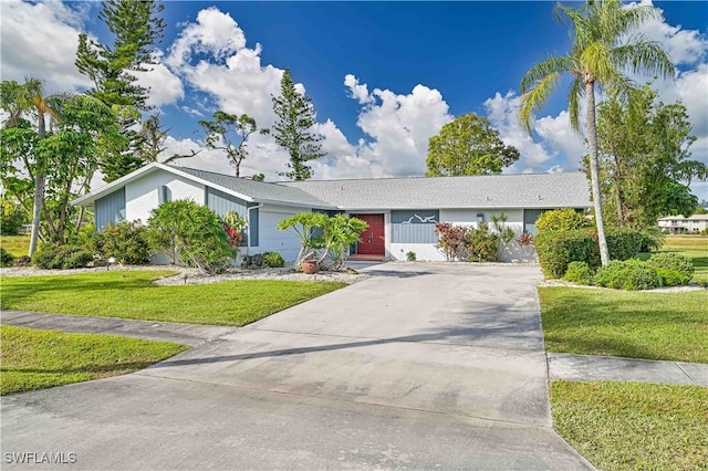 ranch-style home featuring concrete driveway and a front lawn