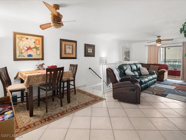 living room featuring ornamental molding, ceiling fan, baseboards, and light tile patterned floors