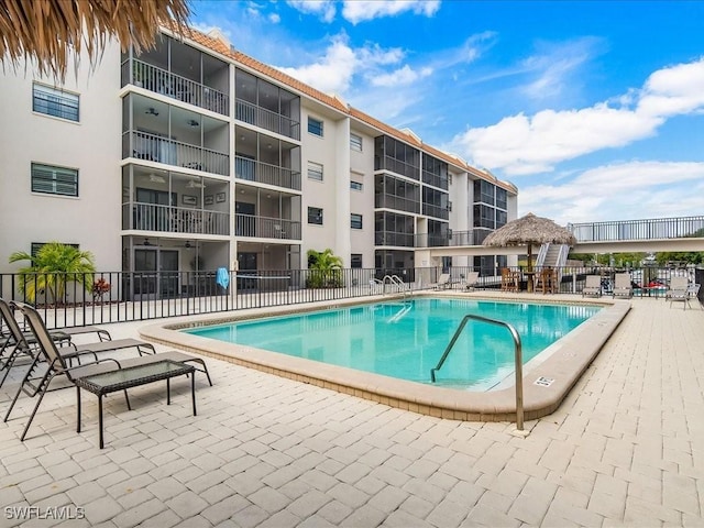 community pool with fence and a patio