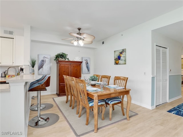 dining space with ceiling fan, visible vents, baseboards, and light wood-style flooring