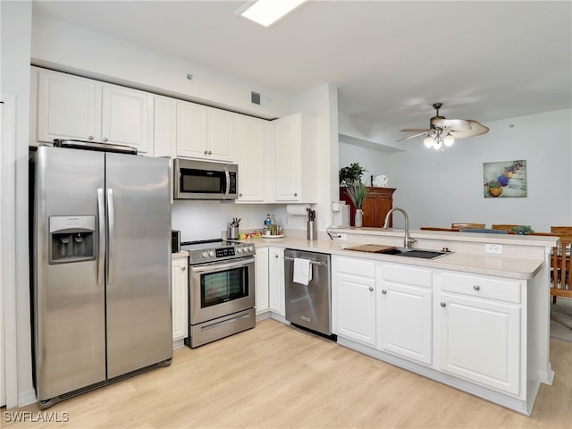 kitchen featuring a sink, stainless steel appliances, a peninsula, and light countertops