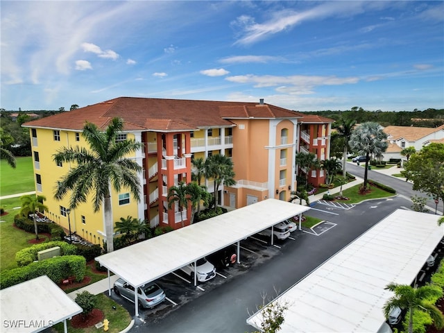 view of property featuring covered and uncovered parking