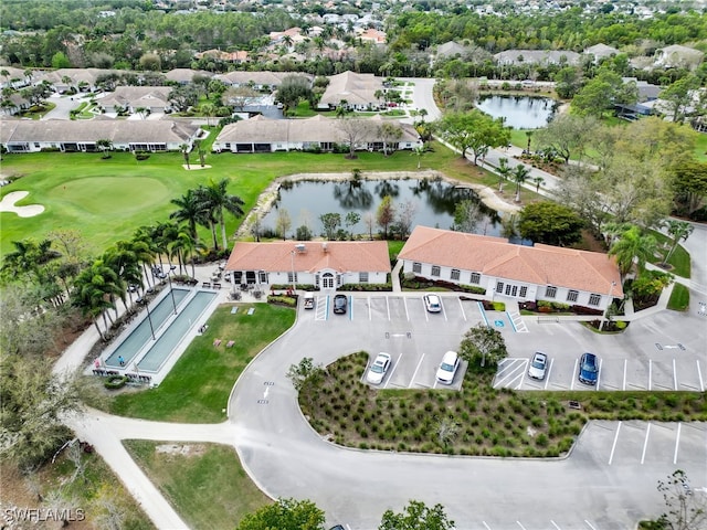 drone / aerial view featuring view of golf course, a water view, and a residential view