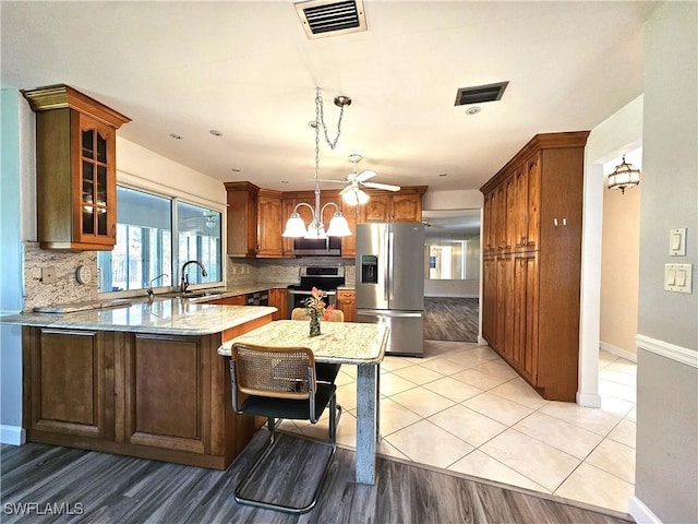 kitchen with glass insert cabinets, an inviting chandelier, visible vents, and appliances with stainless steel finishes