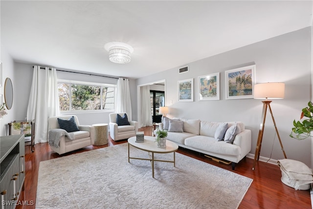 living area featuring dark wood finished floors, visible vents, and baseboards