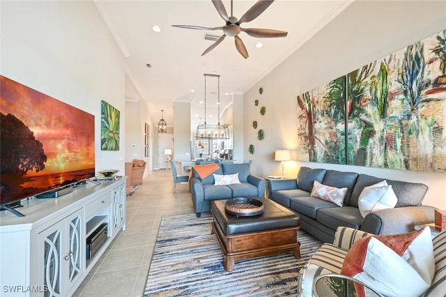 living area with light tile patterned floors, ornamental molding, a high ceiling, ceiling fan with notable chandelier, and recessed lighting