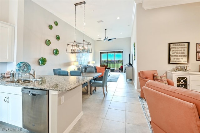 kitchen featuring light tile patterned floors, white cabinets, dishwasher, light stone countertops, and a sink