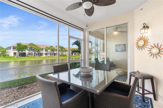 sunroom with a water view and a ceiling fan