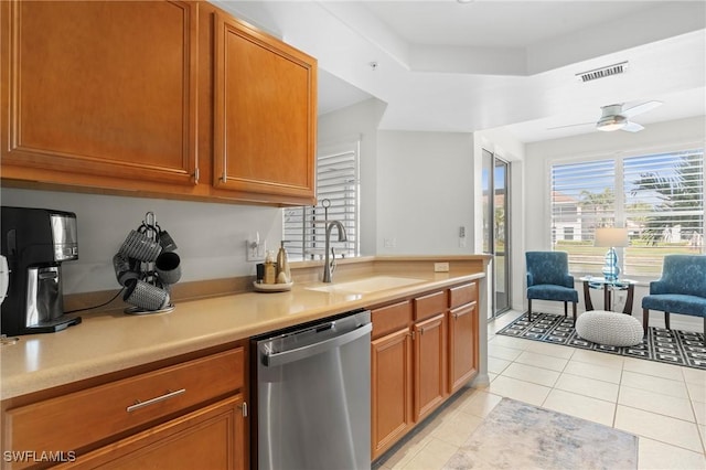 kitchen featuring light countertops, visible vents, light tile patterned flooring, a sink, and dishwasher