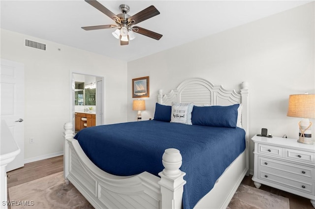 bedroom with baseboards, visible vents, connected bathroom, ceiling fan, and light wood-type flooring