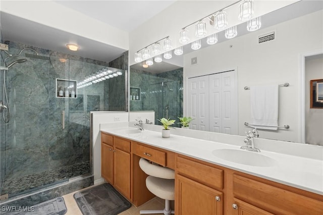 full bath with visible vents, a sink, a marble finish shower, and double vanity