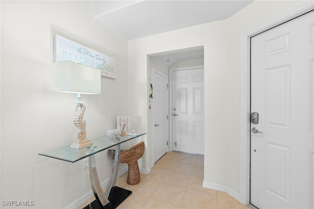 hall with baseboards and light tile patterned flooring