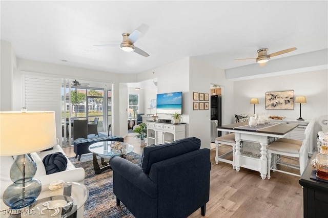 living area with ceiling fan and wood finished floors