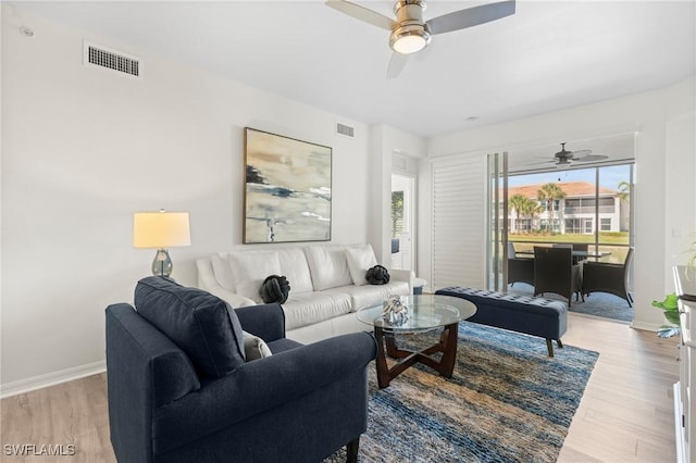 living area featuring light wood-type flooring, visible vents, and baseboards