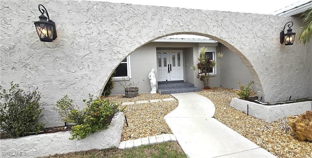 doorway to property featuring stucco siding