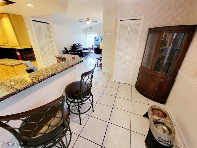 kitchen featuring light tile patterned floors, ceiling fan, light brown cabinets, recessed lighting, and open floor plan