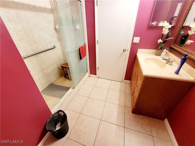 bathroom featuring a shower stall, baseboards, tile patterned flooring, and vanity