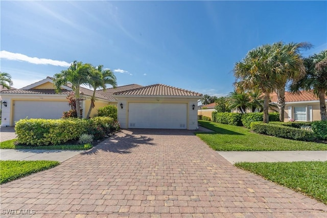 view of front of home with a garage, decorative driveway, a tile roof, and stucco siding