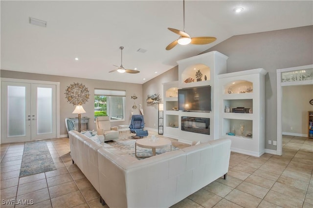 living room with built in shelves, french doors, lofted ceiling, a glass covered fireplace, and light tile patterned flooring