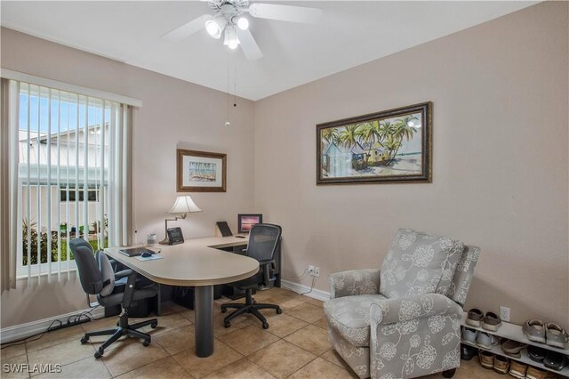 office space featuring ceiling fan, baseboards, and light tile patterned floors