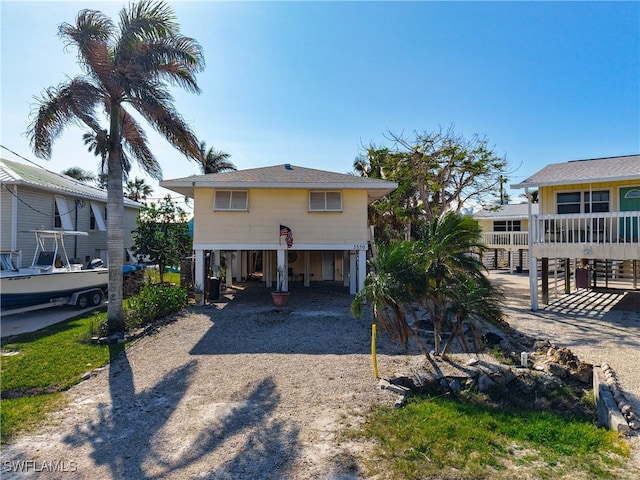 coastal inspired home featuring driveway and a carport