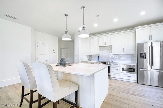 kitchen featuring stainless steel appliances, light countertops, and white cabinetry