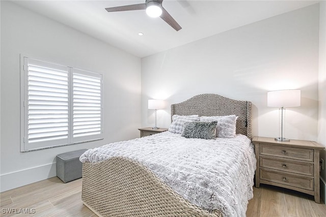 bedroom featuring light wood finished floors, ceiling fan, and baseboards