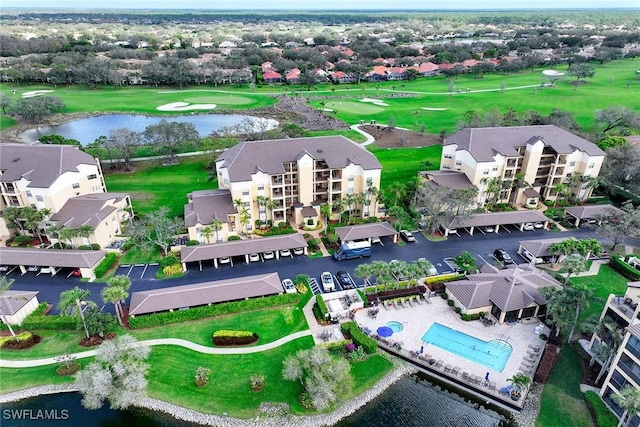 drone / aerial view featuring golf course view and a water view