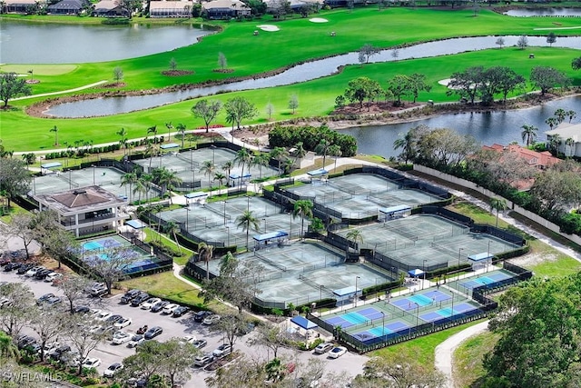 birds eye view of property with view of golf course and a water view