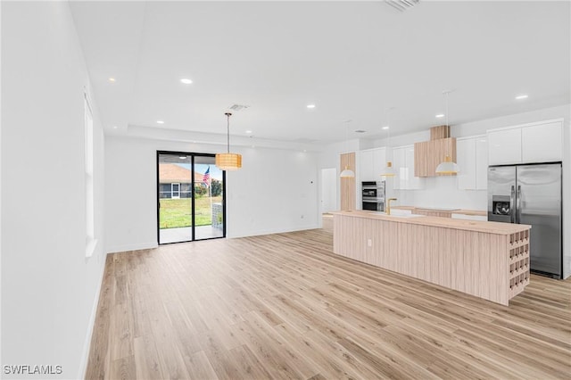 kitchen featuring stainless steel appliances, white cabinets, a center island, modern cabinets, and pendant lighting