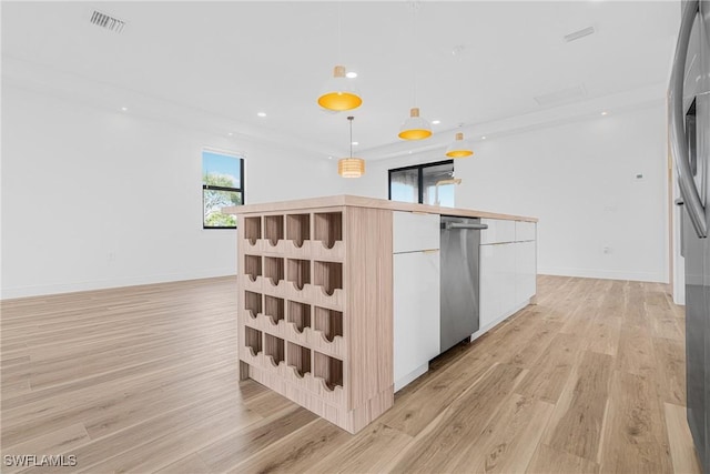 kitchen with stainless steel appliances, visible vents, light countertops, modern cabinets, and decorative light fixtures
