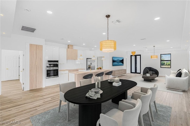 dining space featuring light wood-style floors, visible vents, and recessed lighting