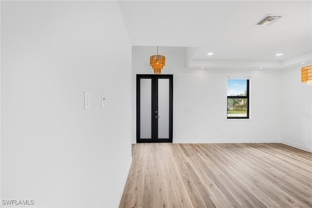empty room with french doors, light wood finished floors, recessed lighting, visible vents, and baseboards