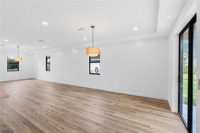 unfurnished room with recessed lighting, light wood-type flooring, visible vents, and baseboards