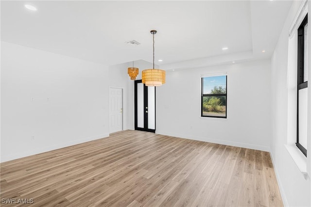 spare room featuring light wood-type flooring, visible vents, baseboards, and recessed lighting
