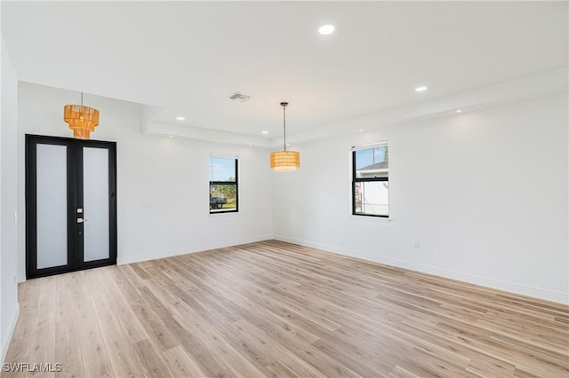 empty room featuring light wood-type flooring, french doors, baseboards, and recessed lighting