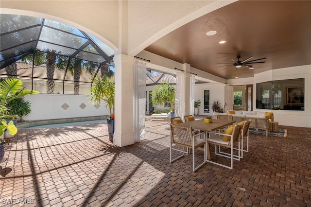 view of patio / terrace with a lanai, ceiling fan, and outdoor dining space