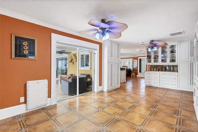 interior space with visible vents, plenty of natural light, baseboards, and ceiling fan