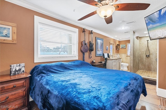 bedroom with ensuite bath, tile patterned floors, a ceiling fan, and crown molding