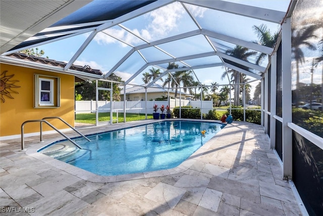 view of swimming pool featuring a lanai, fence, a fenced in pool, and a patio