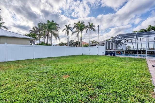 view of yard featuring a fenced in pool, glass enclosure, and a fenced backyard