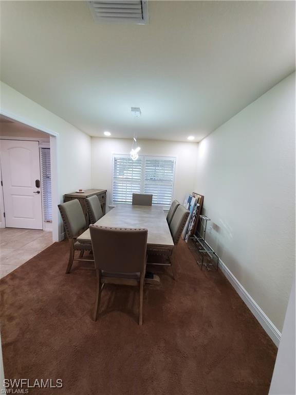 carpeted dining room with baseboards, visible vents, and tile patterned floors