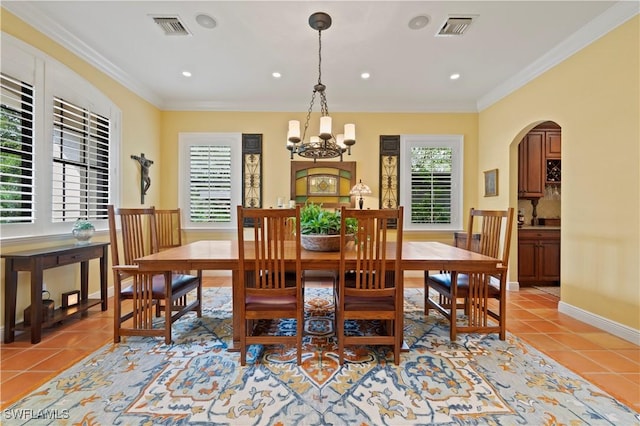 dining area with light tile patterned floors, visible vents, and crown molding