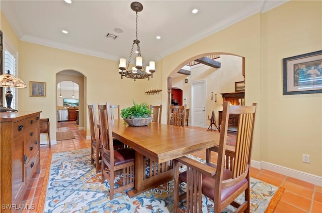 dining area featuring visible vents, arched walkways, a chandelier, and crown molding