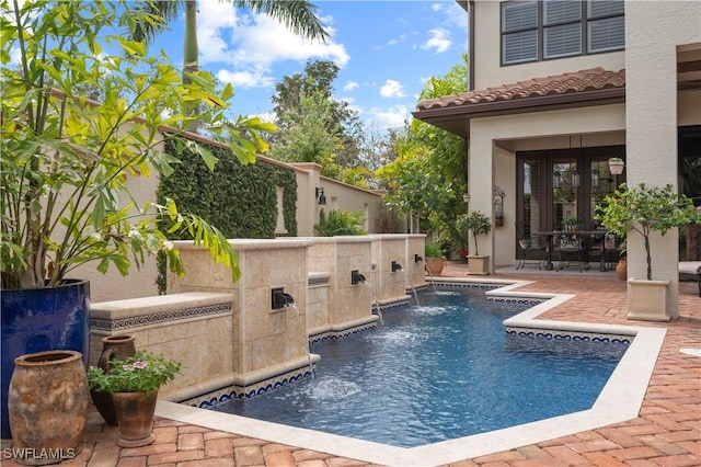 outdoor pool with a patio and french doors