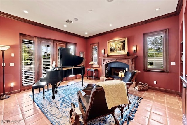 sitting room with a fireplace with raised hearth, crown molding, a wealth of natural light, and baseboards